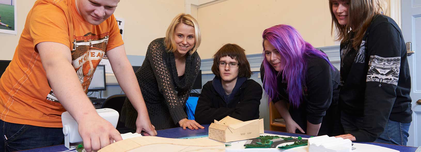 Staff and students looking at paper models