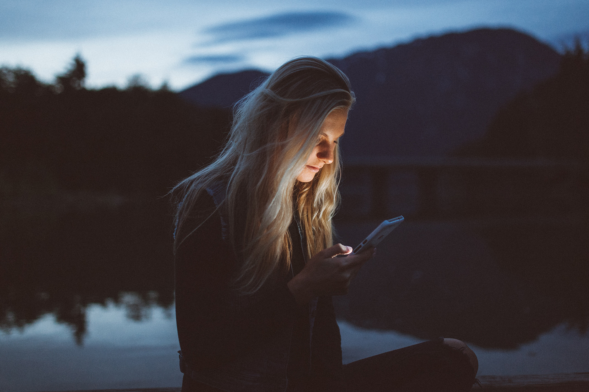 Person on a shore looking at their phone Person on a shore looking at their phone