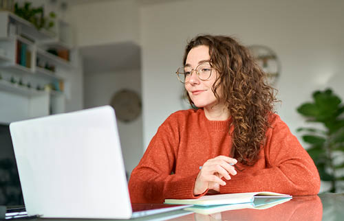 Student sat at a desk working on a laptop